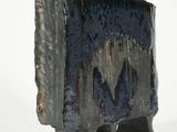 a black vase that is sitting on a white surface