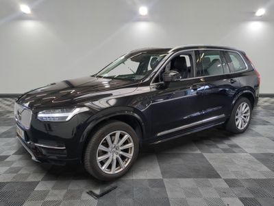 un SUV Volvo noir garé sur un sol à damier dans un showroom