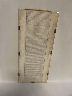 un vieux livre posé sur une table à côté d'un mur blanc
