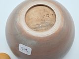 a large brown vase with a wooden lid next to a small wooden object