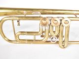 a brass trumpet that is sitting on a white surface