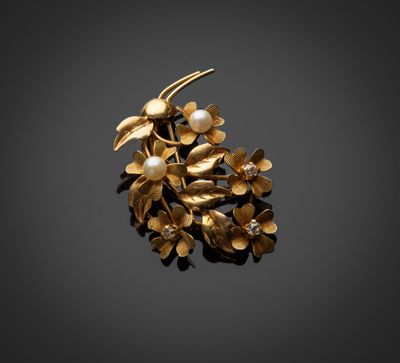 une broche en or ornée de perles et de feuilles sur fond noir