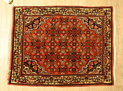 un tapis orange à motifs floraux posé sur un parquet