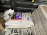 a pile of bags of cement sitting on the floor
