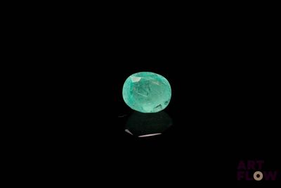 a close up of a green emerald on a black surface
