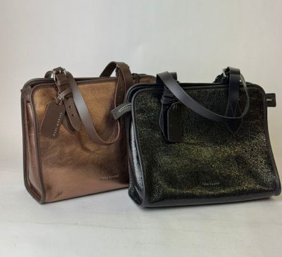 two different colors of handbags sitting side by side on a white surface