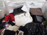 a white bag full of purses and handbags sitting on the floor