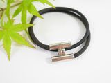 a close up of a black leather bracelet with a silver clasp