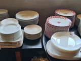 many plates and bowls on the counter in the kitchen
