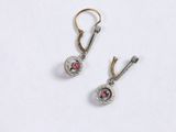 pair of earrings with garnets on them on a white surface