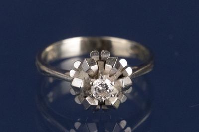 un gros plan d'une bague en diamant posée sur une surface bleue