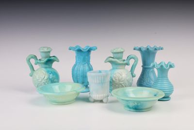 beaucoup de vases et de coupes en verre bleu sur la table