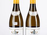 deux bouteilles de vin posées l'une à côté de l'autre sur une surface blanche