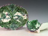 une assiette verte et blanche et un bol posés sur une table