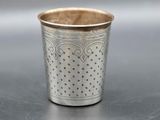 a close up of a silver cup sitting on top of a table