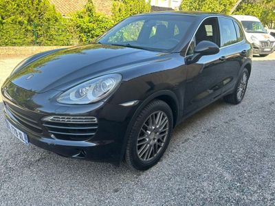 La Porsche Cayenne noire est garée sur le parking.