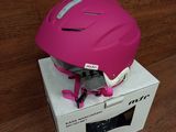 a pink helmet sitting on top of a box on a wooden floor
