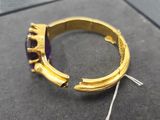 a close up of a gold ring with a purple stone in it