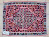 a pink and blue rug on a tile floor with a tag on it