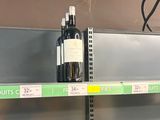 bottles of wine sit on a shelf in a grocery store