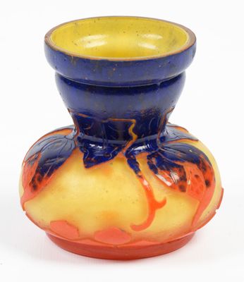 a blue and yellow vase sitting on a white surface
