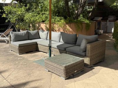 a patio with a couch and a table under an umbrella