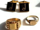 two gold rings and a ring with a black stone on it