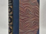 un vieux livre avec une couverture bleue et des lettres dorées