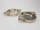 two silver dishes with handles and handles on a white surface