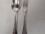two spoons and a fork on a white table