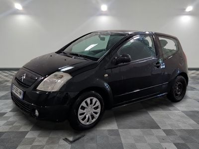 la photo d'une petite voiture noire sur un sol en damier