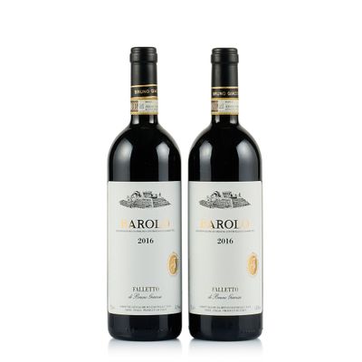deux bouteilles de vin rouge posées l'une à côté de l'autre sur une surface blanche
