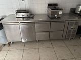 une photo d'une cuisine avec des plans de travail et des appareils électroménagers en inox