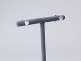 a pair of diamond studded earrings sitting on a stand