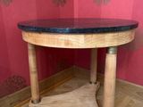 une table en bois avec un plateau noir dans une pièce