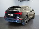 the rear end of a black audi q3 parked in a showroom