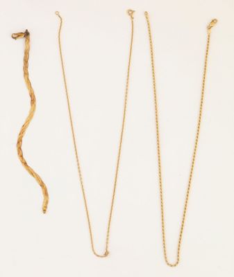 trois colliers en or et un serpent en or sur fond blanc
