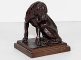 statue d'un chien assis sur un socle en bois, sur fond blanc