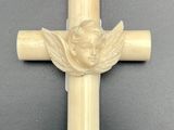 une croix en ivoire sur laquelle est représenté un ange, entourée d'un anneau en or