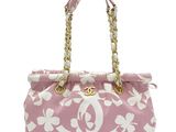a pink and white floral print bag with gold chain handles