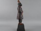 a bronze statue of a man in a coat and hat