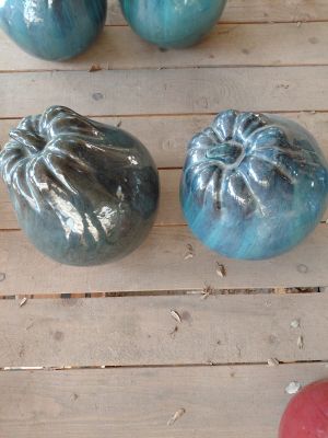 trois citrouilles de couleurs différentes posées sur une table en bois