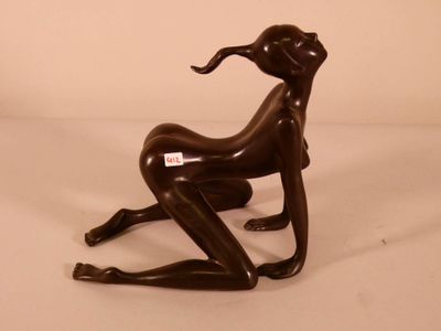 a bronze statue of a woman sitting on a chair