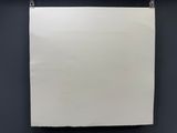 une feuille de papier blanche accrochée à un mur noir