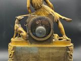 an image of a gold clock with a woman and a dog on it