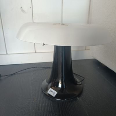 une table noire sur laquelle est posée une lampe blanche