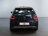 the back of a blue car parked in a large room