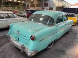 many old cars parked in a garage next to each other