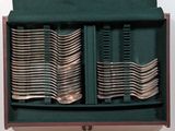 many forks in a green case on the table