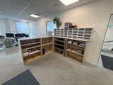 a room with a desk, shelves, and a plant in it